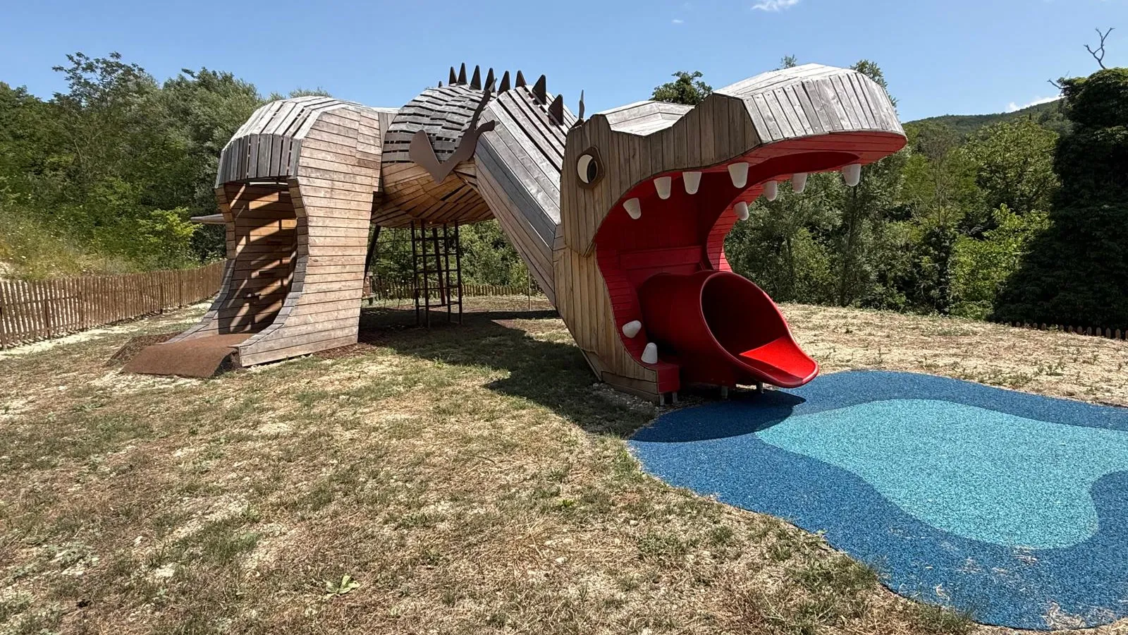 T-Rex Park, Roseto Valfortore. Un dinosauro in legno di robinia percorribile e la sua pozza in antitrauma, nel bosco dei Mulini ad Acqua.